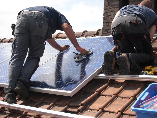 un homme un train de réaliser l'installation de panneaux solaires sur un toit